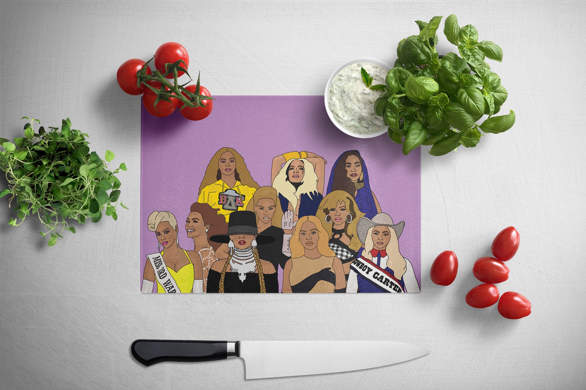 Purple cutting board with illustrated Beyonces surrounded by tomatoes and basil on a white surface.